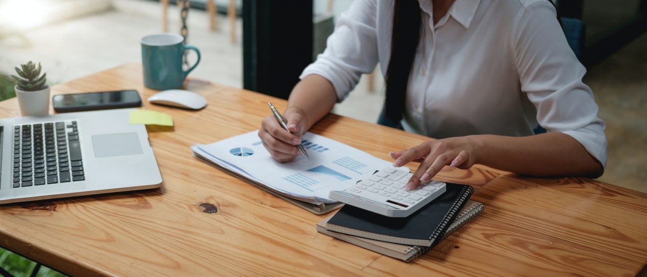 close up asian female accountant or banker making calculations with calculator savings finances